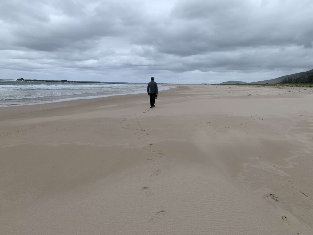 man walking along a beach, home therapy for dementia